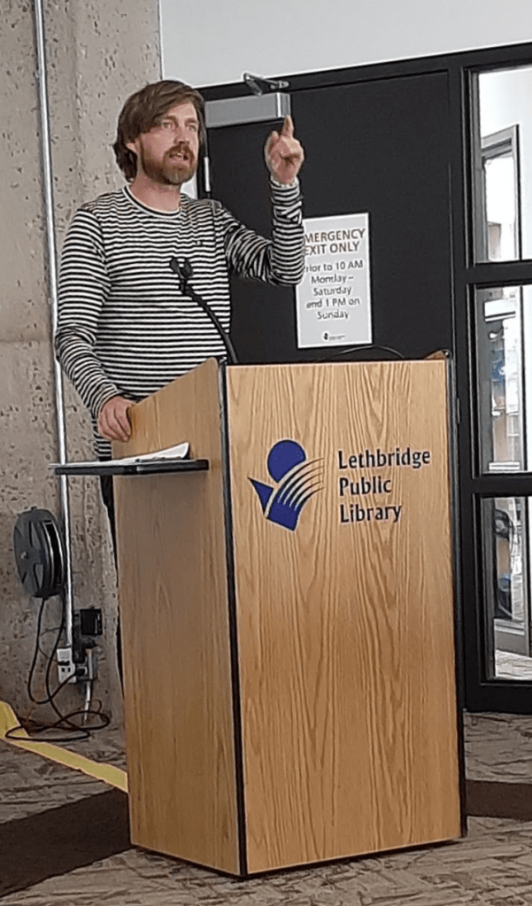A speaker addresses a group at the public library.